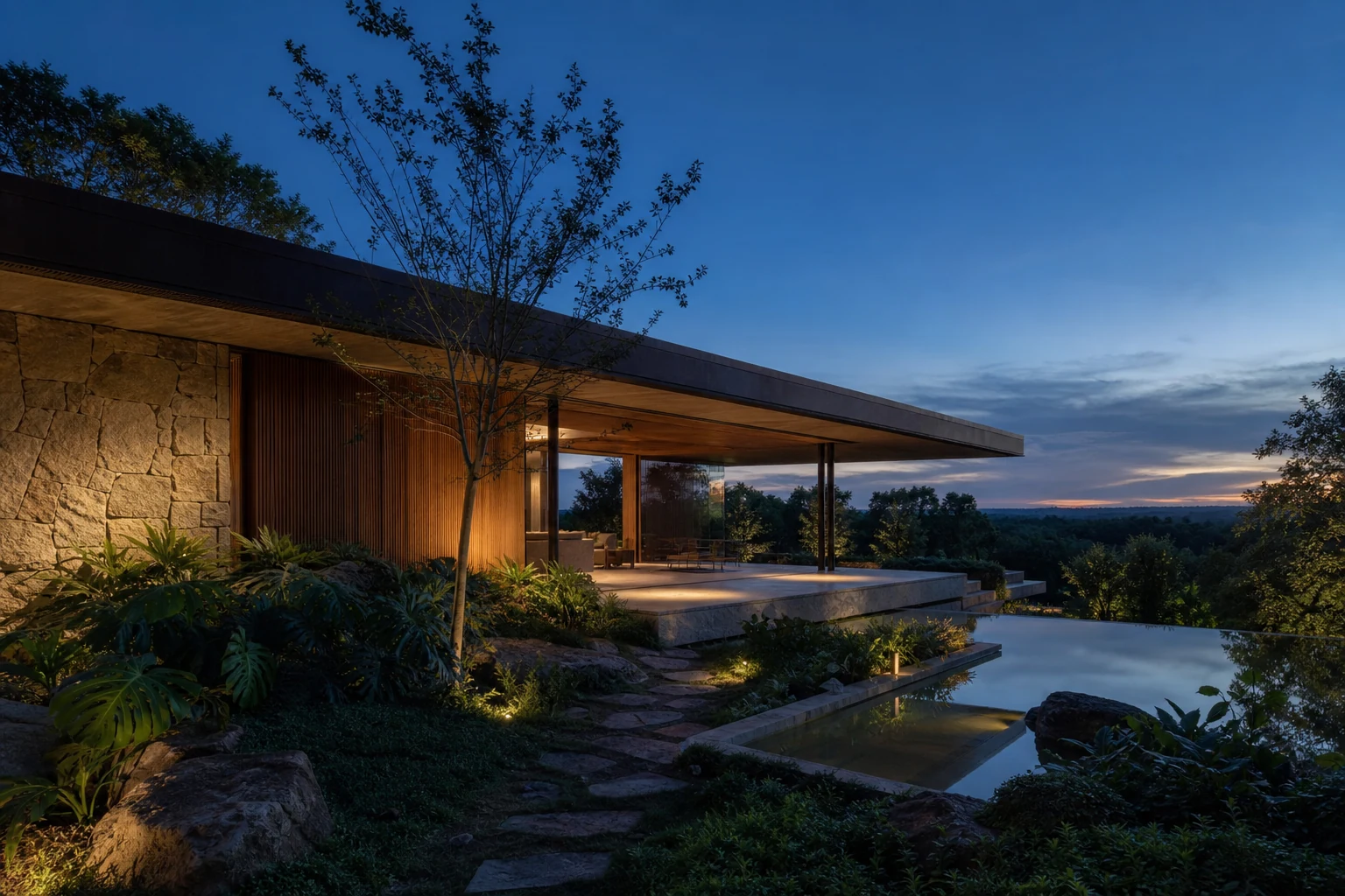 Casa Horizonte ao entardecer, com cobertura horizontal, pedra natural e jardim integrado